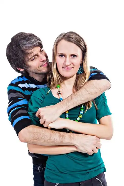 幸福的情侣拥抱,快乐拥抱彼此隔绝在白色背景上的年轻夫妇