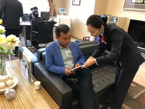 营业部大堂经理在大厅向等候区客户宣传相关知识.