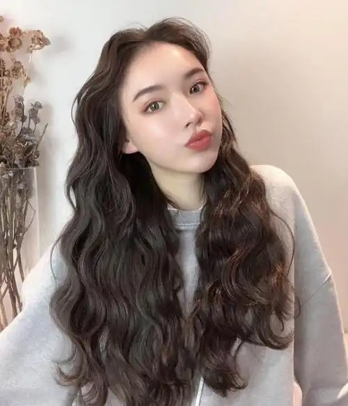 及腰的长发烫一头小卷的发型,显得特别洋气个性,无刘海的设计显得更