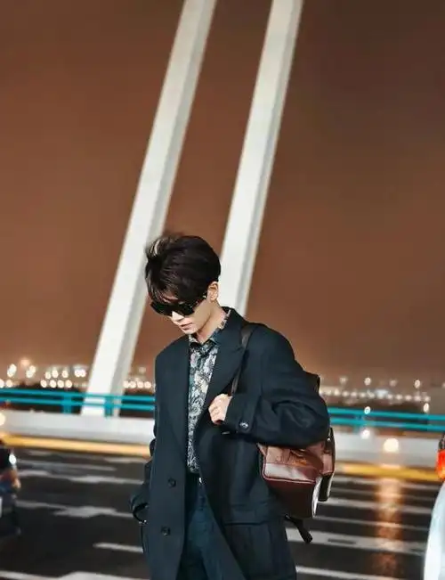 任嘉伦米兰时装周机场出发图曝光,蓝色花衬衫深棕双肩包复古时尚