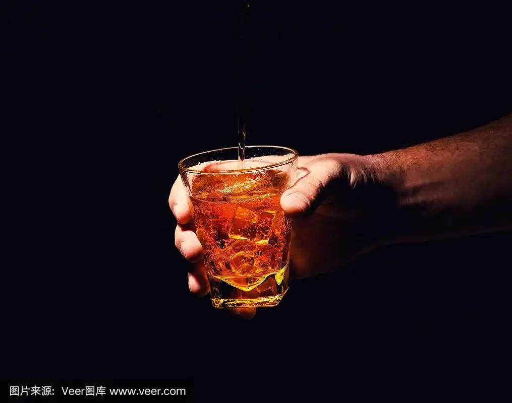 一个男人手里拿着威士忌酒杯