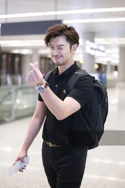 陈柏霖穿格纹棉衣搭配黑色长裤,脚踩黑色长靴,戴着金丝眼镜气质文雅