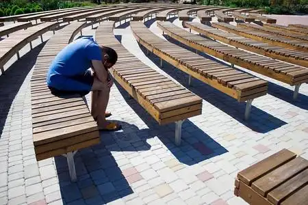 在街头剧场的众多长椅中一个人坐在他图片素材