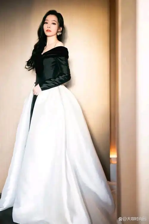 张靓颖身着一套典雅的黑色与纯粹的白色相间的礼服,展现出她独特的的
