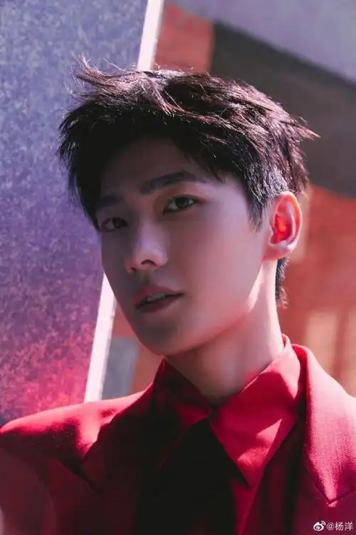 杨洋米兰时装周造型曝光,身穿暗红色西装搭配金v黑领带,在阳光下亮丽