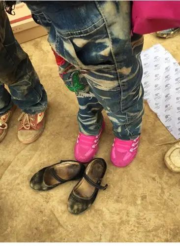 小女孩穿上了新跑鞋,她说自己从来没穿过这么漂亮的鞋子