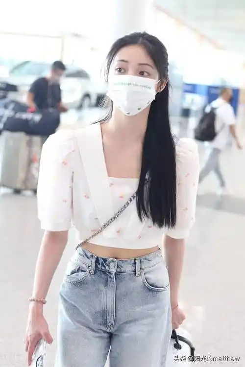 周洁琼白色露脐上衣牛仔裤现身机场长发披肩温柔尽显