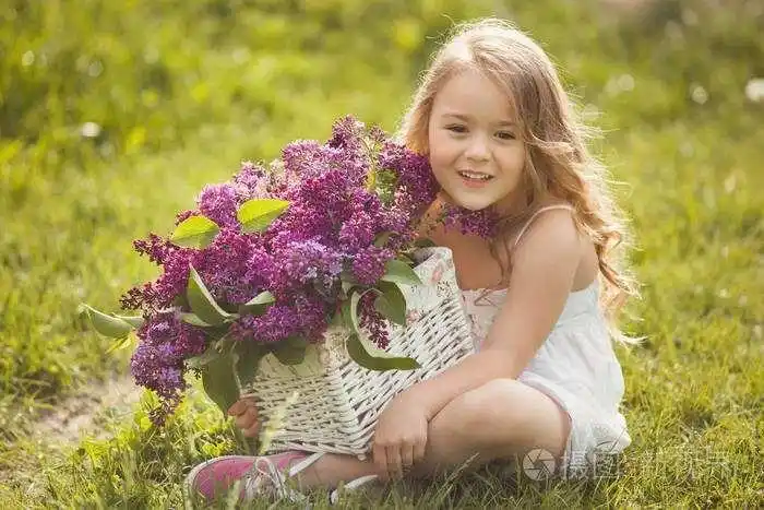 照片 可爱的小女孩在户外与春天的花朵.漂亮的孩子.jpg
