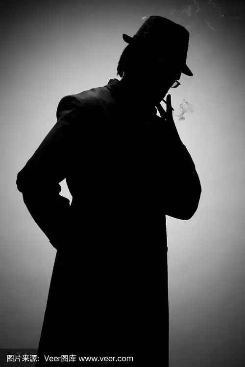 一个戴着帽子抽烟的男人的剪影,在灰色的背景上