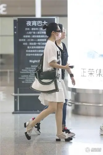 许晴现身机场懒理花少风波 与助理搭肩笑弯腰