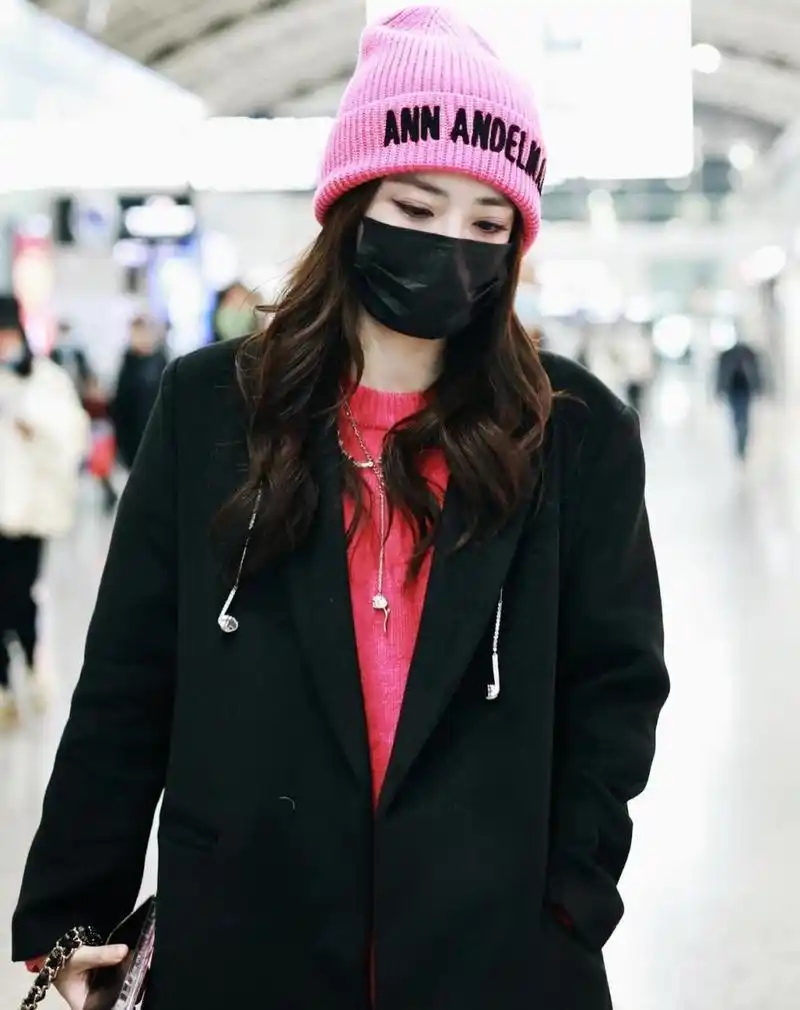 徐璐机场私服穿搭 身穿黑色大衣内搭粉红毛衣,头戴粉色毛线帽,皮裤