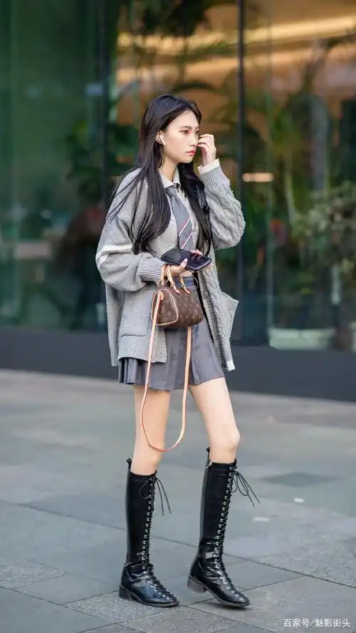 秋冬时节,时尚街区的美女选择高筒靴搭配服饰,显高显瘦显腿长