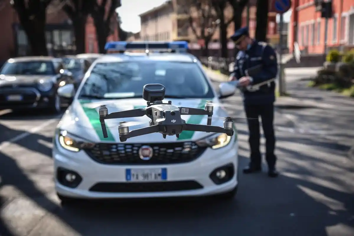 3月24日,在意大利米兰附近,一架察看"封城"情况的无人机飞在警车旁.