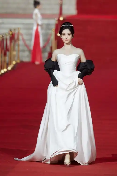 法国梧桐下,@祝绪丹bambi一袭白缎面墨色玫瑰礼服袅袅摇曳,漾开一抹