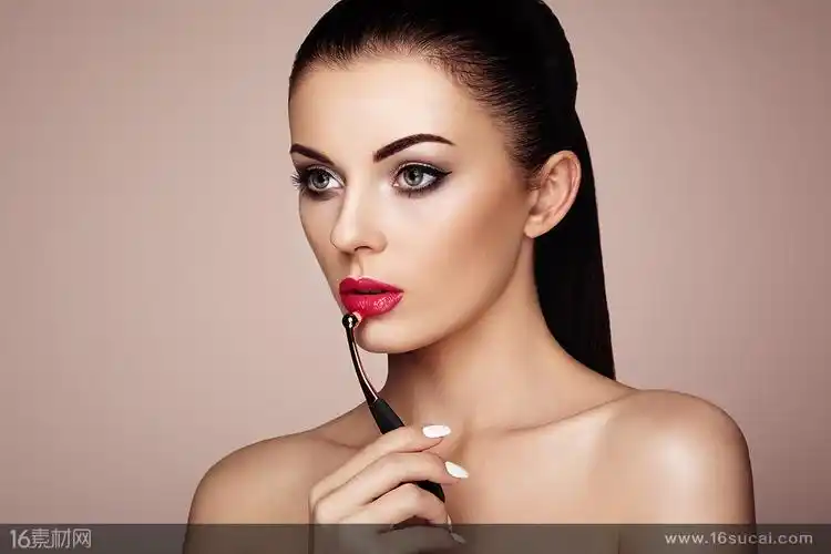 拿着口红刷化妆的美女高清图片