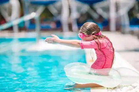 活泼可爱小孩活泼可爱的小女孩在室外游泳池准备游泳照片