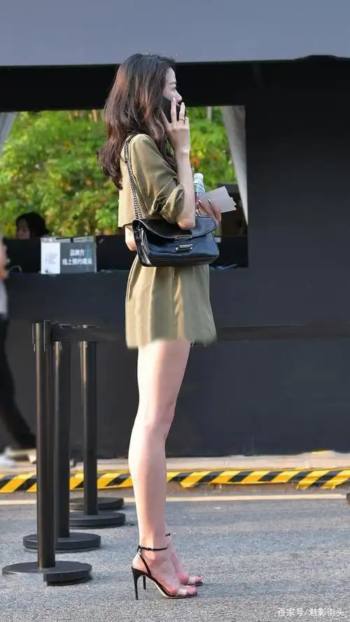美女用一字带高跟凉鞋搭配军绿色短风衣,展现大长腿,精气神十足