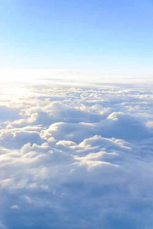 从飞机的窗口观看在空中飞行的云朵,俯视云海般的天空背景图片下载