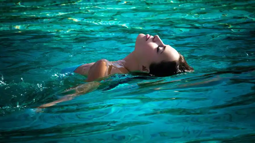 女孩在游泳池里游泳 4k