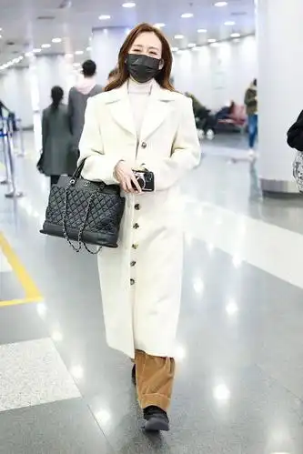 2021年3月8日,北京,王鸥机场街拍. 手袋:chanel王鸥身穿白色的呢大衣.