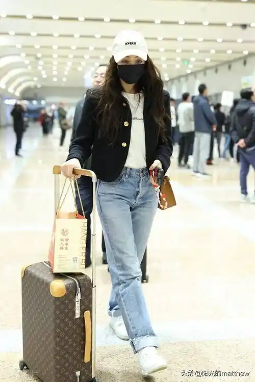 麦迪娜现身北京机场黑色外套搭配牛仔裤简约利落