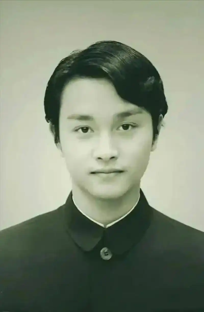 张国荣,年轻时的照片中,他穿着一件黑色中山装,目光清澈明亮,面容端庄