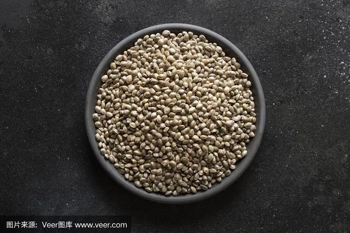 有机干燥的大麻种子在黑色的碗,在黑色的背景.从以上观点.