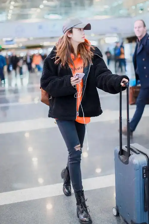 刘芸身穿黑色紧身破洞牛仔裤秀修长美腿,搭配上今年冬天大热的马丁靴