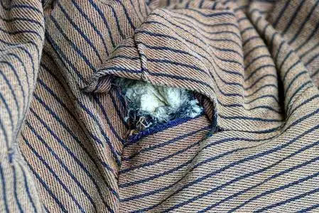 衣衫褴褛的衣服棕色条纹旧衣服上破洞照片