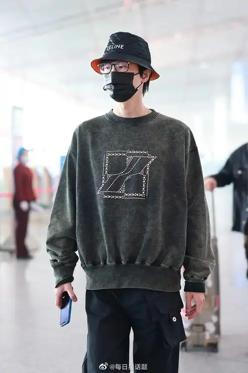 2022年4月9日,北京,许嵩穿墨绿色卫衣戴celine渔夫帽现身机场,帅气