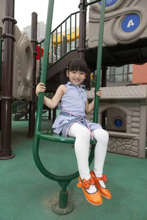 小女孩在幼儿园内玩滑梯