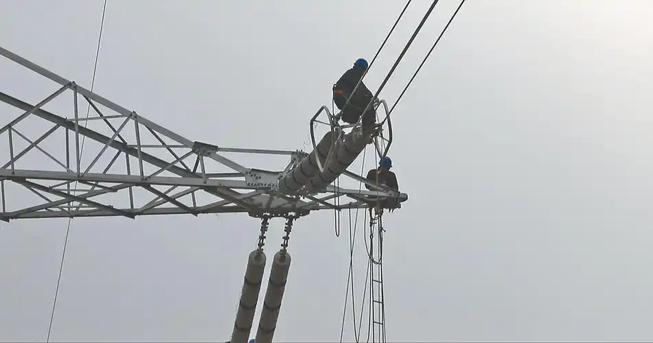 施工人员在铁塔上安装均压环.