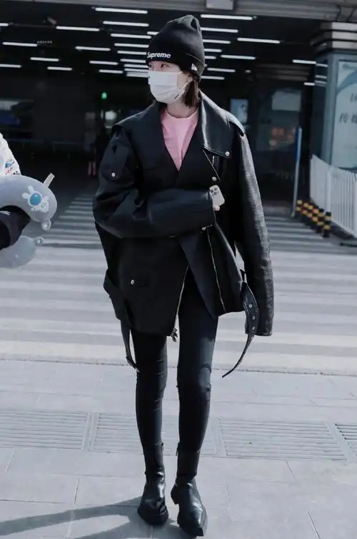 乔欣机场私服look,身穿黑色机车夹克下搭修身牛仔裤与切尔西短靴,头戴