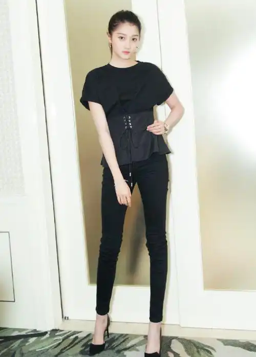 而关晓彤搭配的是一条黑色紧身裤,脚踩黑色高跟鞋,关晓彤一身黑色的