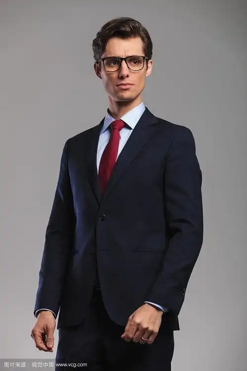 穿西装打领带戴眼镜的男人看向一边