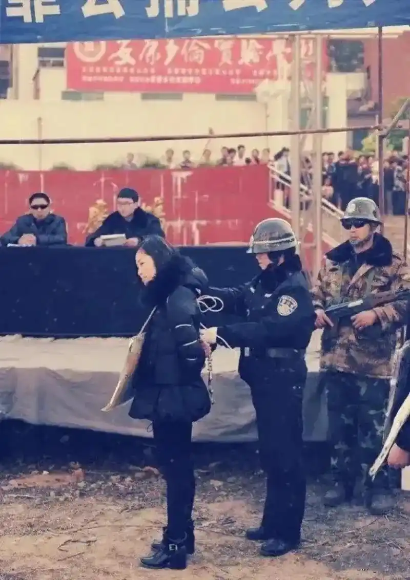 这张照片拍摄于上世纪90年代,公审大会现场,一个女囚犯被绑上了法绳