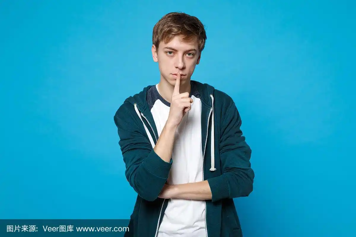 有吸引力的年轻男子的肖像在休闲衣服说嘘,安静与手指在嘴唇嘘手势