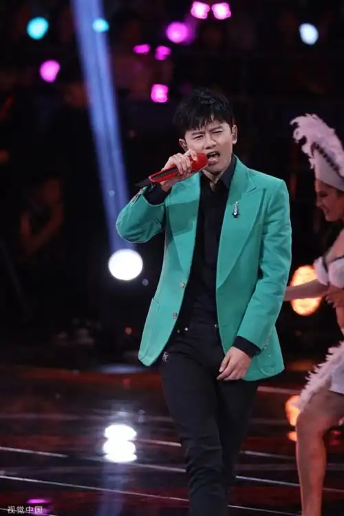 张杰绿西装举红话筒醒目惹眼 首唱百万富翁很应景