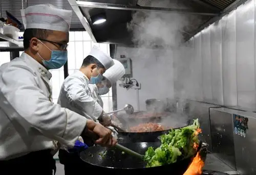 2月6日,厨师在炒菜.