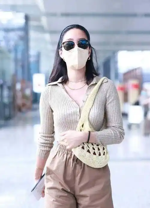 杨采钰机场穿搭真大胆,露脐针织衫故意解开纽扣,上v下