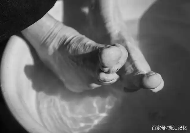 一位老人正在用热水洗她的小脚.(2016年)