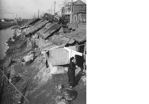 1947年12月,在河边贫民窟晾晒衣服的女人.