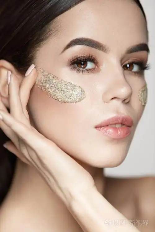 女人的脸部皮肤护理.美丽的女孩,用化妆品磨砂面膜