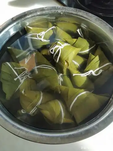 最后是煮粽子,煮粽子时先在锅中垫上一层箅子,把包好的粽子一个个摆放