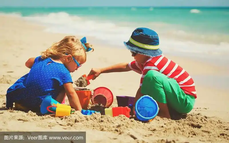 孩子们在夏天的海滩上玩沙子