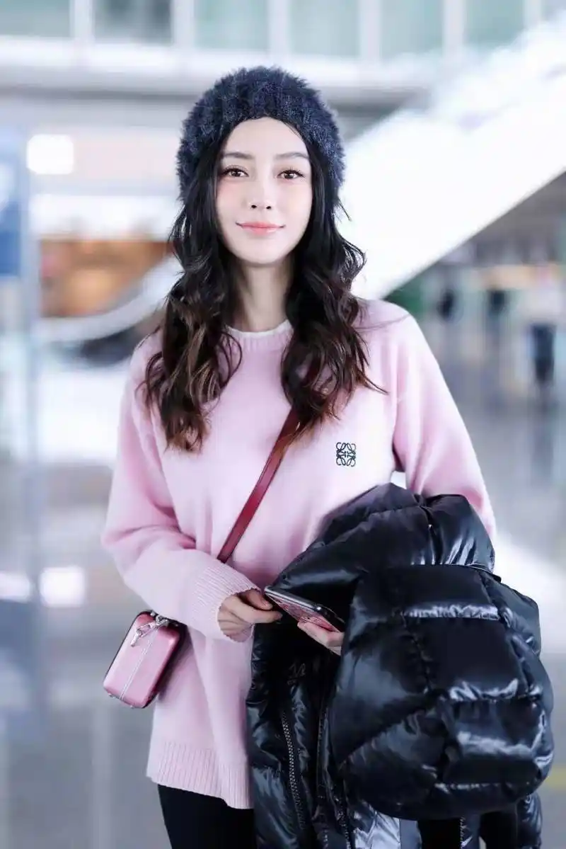 angelababy穿粉衣走机场,烫波浪大卷发,露温柔甜笑美似洋娃娃