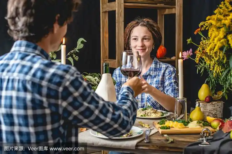 周末约会,喝红酒,吃意大利面.晚餐与秋天的鲜花为情侣在一个乡村风格