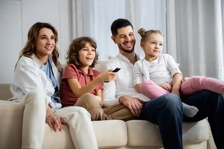 幸福的一家四口在看电视男孩打开他最喜欢的电影