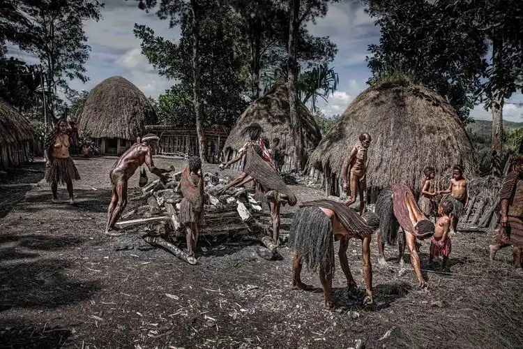 部落男女把石头放在柴木台上,这些石头会被放火烤烫