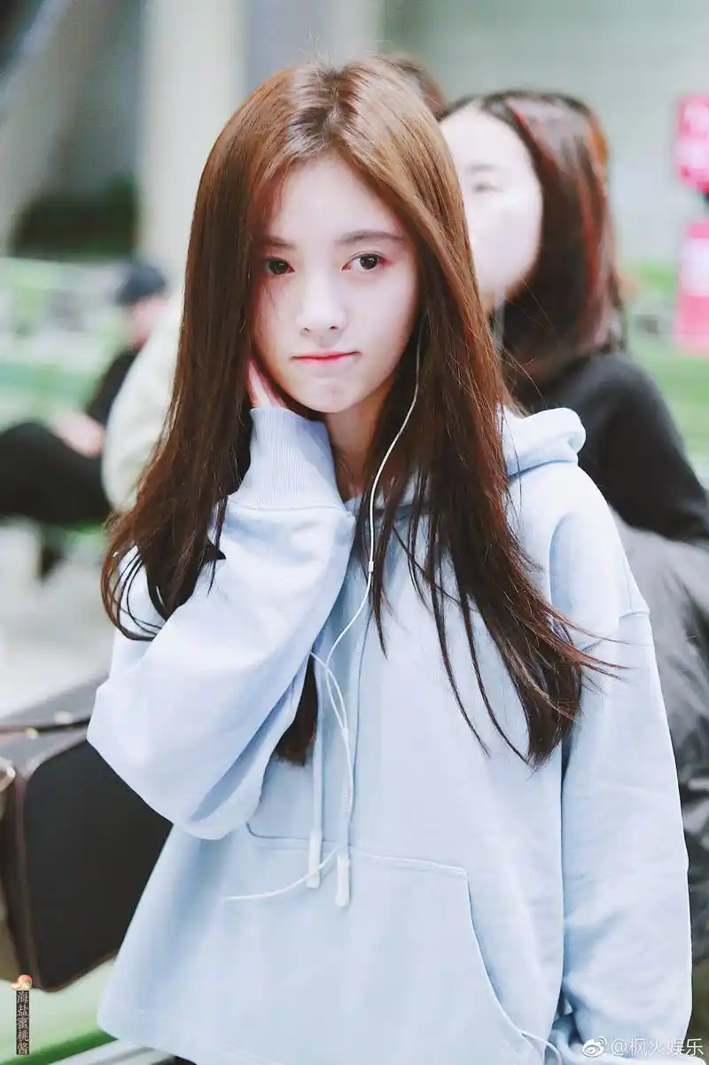 鞠婧祎穿蓝色连帽卫衣现身机场皮肤白皙